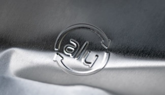 Embossed aluminum recycling logo with 'alu' on a brushed metal background