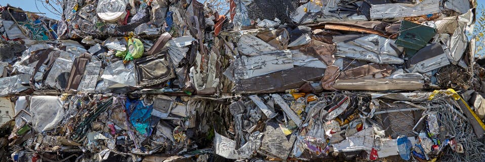 Compressed cube of mixed recyclable scrap metal in a recycling yard.